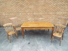 A pine dining table measuring approximately 73 cm x 172 cm x 99 cm with four chairs and two carvers.