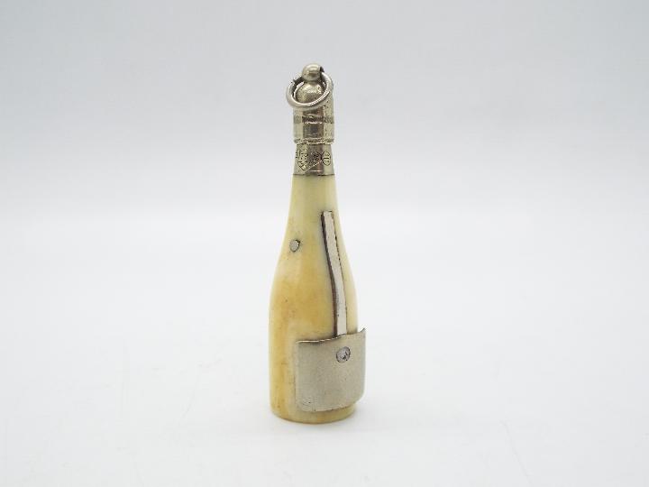 A late Victorian ivory and white metal novelty cigar cutter in the form of a champagne bottle, - Image 2 of 4