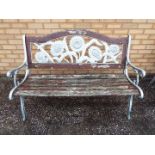 A cast iron and wood slat garden bench with sunflower design to the backrest,