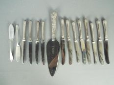 A silver handled cake server and two sets of six silver handled butter knives,