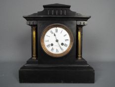 A late 19th century French black slate mantel clock of architectural form,