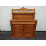 A pine sideboard with twin door cupboard below frieze drawer,