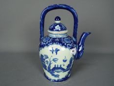A large blue and white teapot decorated with panels of landscape scene, four character,