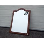 A wood framed, bevel edge wall mirror with floral decoration,