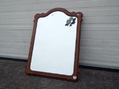 A wood framed, bevel edge wall mirror with floral decoration,