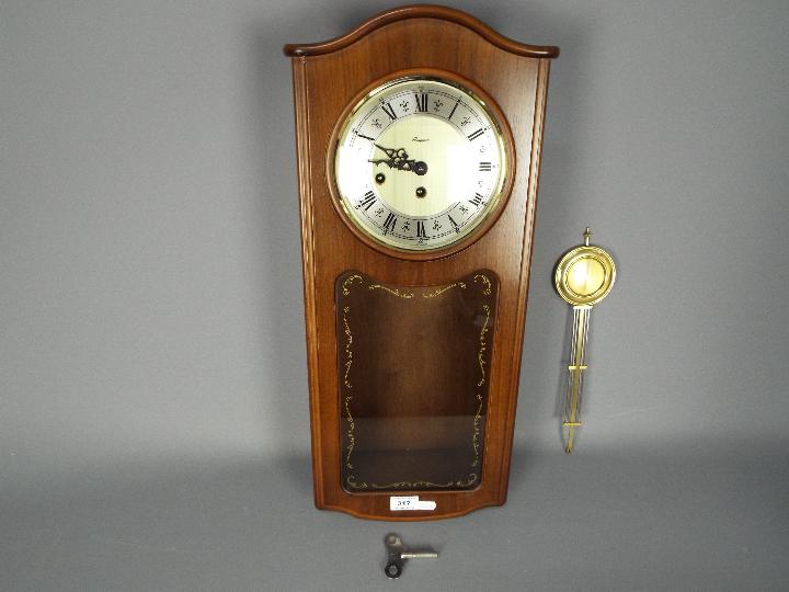 A late 20th century Rapport, Westminster chime, wall clock with key and pendulum,