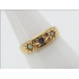A 15ct gold ring set with a blue stone and two small white opal cabochons, size P,