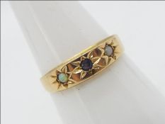 A 15ct gold ring set with a blue stone and two small white opal cabochons, size P,