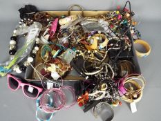 A quantity of mixed costume jewellery, bracelets, necklaces, watches, rings and similar.