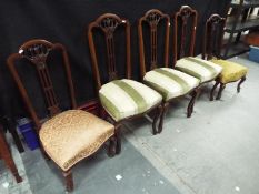 Five dining chairs with upholstered seats and carved detailing.