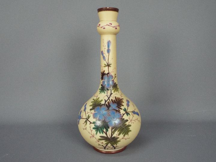 An early 20th century glass vase with hand painted floral decoration, signed to the base,