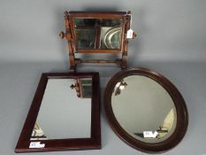 A mahogany framed toilet mirror and two wall mirrors.