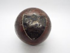 An antique cricket ball with silver presentation shield M.F.C.C.C J Sayle Hat Trick Aug 12th 1911.