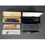 A vintage Parker Duofold pen and pencil set, a further Parker fountain pen and two others.