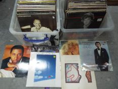 Two boxes of 12" vinyl records to include Simon and Garfunkel, Lionel Ritchie, George Benson,