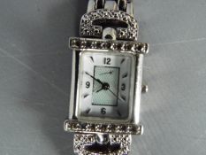 A lady's sterling silver cased, stone set wristwatch on white metal bracelet.