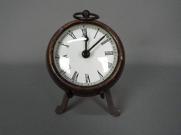 A small, antique style desk clock in the form of a pocket watch, with stand,