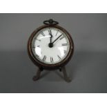 A small, antique style desk clock in the form of a pocket watch, with stand,