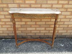 A marble topped console table on fluted supports and with gilt metal mounts,