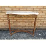 A marble topped console table on fluted supports and with gilt metal mounts,