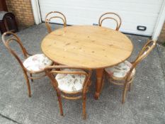 A pine kitchen table, 73 cm x 118 cm, and five chairs.