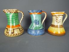 Three Art Deco, Myott pinch neck jugs with hand painted decoration, largest approximately 21 cm (h).