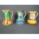 Three Art Deco, Myott pinch neck jugs with hand painted decoration, largest approximately 21 cm (h).