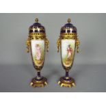 A pair of Sevres style, gilt metal mounted urns,