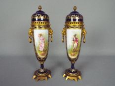 A pair of Sevres style, gilt metal mounted urns,