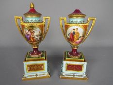 A pair of late 19th or early 20th century Vienna style, porcelain urns and covers,