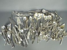 A collection of loose flatware, plated and stainless.