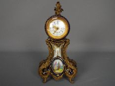 A Sevres style porcelain cased desk clock with metal mounts,