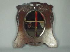 An Art Nouveau style wall mirror with oval, bevel edge plate, approximately 65 cm x 55 cm.