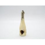 A late Victorian ivory and white metal novelty cigar cutter in the form of a champagne bottle,