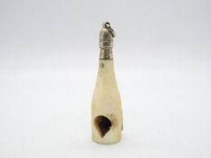 A late Victorian ivory and white metal novelty cigar cutter in the form of a champagne bottle,