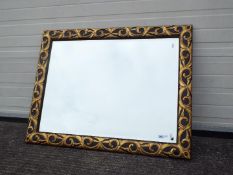 A large bevel edge wall mirror with black and gold coloured frame, approximately 83 cm x 110 cm.