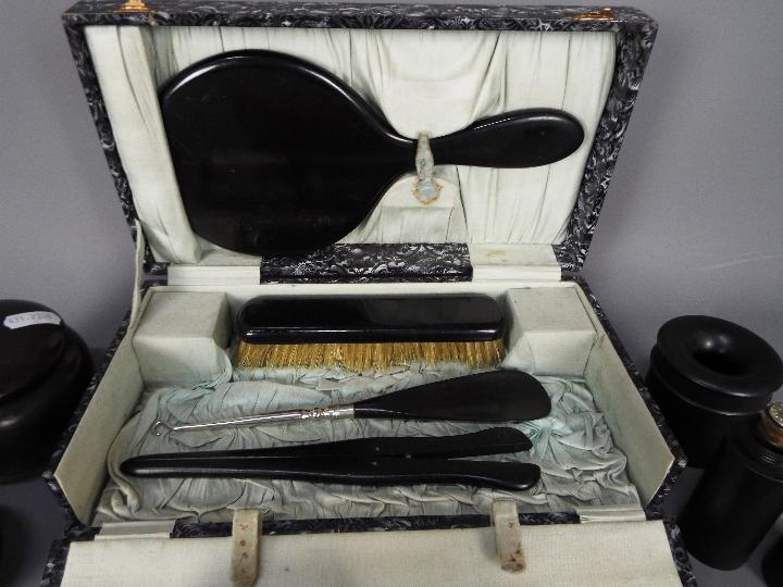 A lady’s vintage cased travel set containing Ebony dressing table items comprising a bevel edged - Image 2 of 5