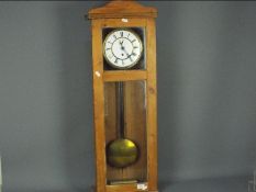 A pine cased wall clock, approximately 90 cm x 31 cm.