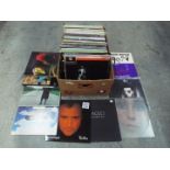 A large box of 12" vinyl records to include Gary Numan, Dead Or Alive, Cher, The Eagles,