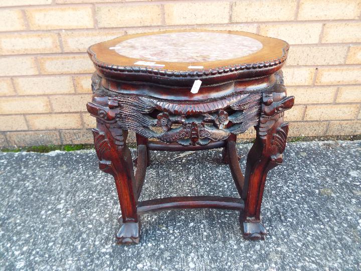 A Chinese, hardwood jardiniere stand with carved detailing and inset marble top,