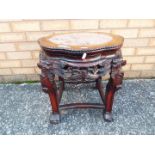 A Chinese, hardwood jardiniere stand with carved detailing and inset marble top,