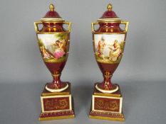 A pair of Vienna style, porcelain urns and covers,