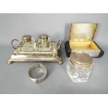 Lot to include an Art Deco silver plated cigarette box, plated ink well stand with two glass wells,