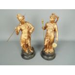 A pair of metal sculpture depicting figures in classical dress, approximately 35 cm (h).