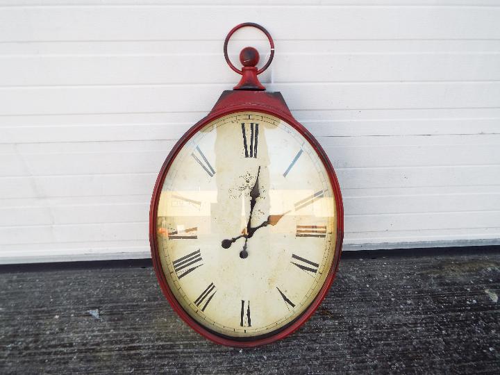 A large, antique style wall clock in the form of a pocket watch, approximately 97 cm x 46 cm.