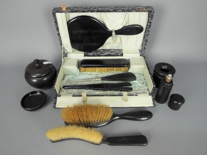 A lady’s vintage cased travel set containing Ebony dressing table items comprising a bevel edged