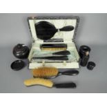 A lady’s vintage cased travel set containing Ebony dressing table items comprising a bevel edged