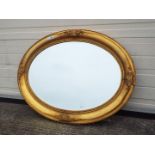 An oval framed, bevel edge wall mirror, approximately 88 cm x 67 cm.