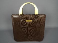 A vintage Mulberry handbag with gold tone arch handles, lined with single zip internal pocket,