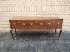 An Edwardian sideboard having three drawers, approximately 83 cm x 194 cm x 46 cm.